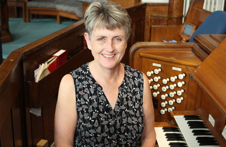 Nancy Martin, Music Director, Sitting at the organ.